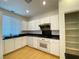 Functional kitchen with white cabinetry, black countertops, modern appliances, and hardwood flooring at 6240 Winston Falls Ave, Las Vegas, NV 89139