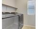 Modern laundry room with stainless steel washer and dryer and built-in shelving at 6679 Salt Pond Bay St, Las Vegas, NV 89149