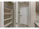 Pantry with shelving located near a hallway with tile flooring, white doors, and security system at 6679 Salt Pond Bay St, Las Vegas, NV 89149