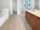 Bathroom with tiled floor, double sink vanity, and separate tub and shower at 7211 Hickory Post Ave, Las Vegas, NV 89179