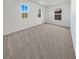 Empty bedroom with plush carpet, three windows, and white walls at 7211 Hickory Post Ave, Las Vegas, NV 89179