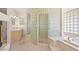Luxurious main bathroom featuring glass block shower, soaking tub, and dual sinks at 736 N Kiel St, Henderson, NV 89015