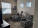 Cozy sitting area with two grey upholstered chairs, a lamp table, and soft natural light at 742 Agave Falls St, Henderson, NV 89011