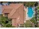 Overhead view of a house with red-tiled roof, pool, spa and palm trees, next to lush backyard at 7808 Foothill Ash Ave, Las Vegas, NV 89117