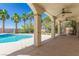 Covered backyard patio with ceiling fans overlooking a sparkling pool and mature landscaping at 7808 Foothill Ash Ave, Las Vegas, NV 89117