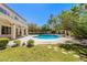 Beautiful backyard with a pool, mature trees, and a well-maintained lawn at 7808 Foothill Ash Ave, Las Vegas, NV 89117