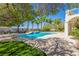 Inviting backyard features a sparkling pool, lush landscaping, and mature trees at 7808 Foothill Ash Ave, Las Vegas, NV 89117