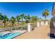 Balcony view of a sparkling pool surrounded by palm trees and desert landscape in this single Gathering home at 7808 Foothill Ash Ave, Las Vegas, NV 89117