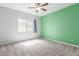 Cozy bedroom with carpet, ceiling fan, and a window offering natural light and backyard views at 7808 Foothill Ash Ave, Las Vegas, NV 89117