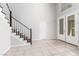 Bright foyer featuring tile flooring, a staircase, and a double door entrance, providing a welcoming ambiance at 7808 Foothill Ash Ave, Las Vegas, NV 89117