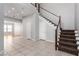 Bright foyer featuring tile flooring, a staircase, and a double door entrance, providing a welcoming ambiance at 7808 Foothill Ash Ave, Las Vegas, NV 89117