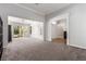 Spacious living area with plush carpeting and a view of the outdoor patio at 7808 Foothill Ash Ave, Las Vegas, NV 89117