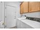 Bright laundry area with modern appliances, door to the outside and storage cabinets at 7886 Palace Monaco Ave, Las Vegas, NV 89117