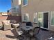 Relaxing backyard patio with wicker furniture, dining table, brick perimeter wall and neutral-colored stucco exterior at 8113 Mineola Palms St, Las Vegas, NV 89139