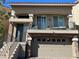 Inviting exterior showcasing a balcony and a two-car garage with brick accents at 8113 Mineola Palms St, Las Vegas, NV 89139