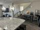 Open-concept kitchen and dining area with granite countertops and modern hanging lights at 8113 Mineola Palms St, Las Vegas, NV 89139