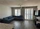 Cozy living room with large sectional sofa, wood-style floors, and plantation shutters at 8113 Mineola Palms St, Las Vegas, NV 89139