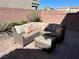 A cozy patio with a comfortable wicker sectional, throw pillows and an ottoman for outdoor relaxation at 8113 Mineola Palms St, Las Vegas, NV 89139