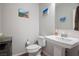 This half bathroom features a toilet, a sink with a pedestal, and a light grey accent wall at 9643 Ponderosa Skye Ct, Las Vegas, NV 89166
