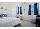 This bedroom has a full size bed with a patterned comforter, a small desk, and blue curtains at 9643 Ponderosa Skye Ct, Las Vegas, NV 89166