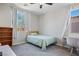 This bedroom has a twin bed, a ceiling fan, and a window with light-filtering curtains at 9643 Ponderosa Skye Ct, Las Vegas, NV 89166