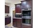 Built-in microwave and oven combination unit, and rich wood cabinetry and granite counters at 9643 Ponderosa Skye Ct, Las Vegas, NV 89166
