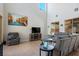 Bright living room with high ceilings, gray sofa, and a fireplace under the mounted television at 9643 Ponderosa Skye Ct, Las Vegas, NV 89166