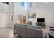 Bright living room with high ceilings, gray sofa, and a view to the outside patio at 9643 Ponderosa Skye Ct, Las Vegas, NV 89166