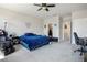 This bedroom has a large window, blue bedding, and a home office area with multiple chairs at 9643 Ponderosa Skye Ct, Las Vegas, NV 89166