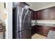 Stainless steel refrigerator next to rich wood cabinetry and granite counters at 9643 Ponderosa Skye Ct, Las Vegas, NV 89166