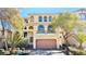 Charming two-story home with desert landscaping, a balcony, arched windows, and a terracotta-colored tile roof at 10716 Shasta Glow Ct, Henderson, NV 89052