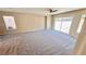 Large living room with neutral carpet, ceiling fan, and sliding glass doors at 10716 Shasta Glow Ct, Henderson, NV 89052