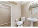 Well-lit half bathroom with a pedestal sink, toilet, and a closet at 11094 Arcadia Sunrise Dr, Henderson, NV 89052