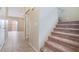 Hallway featuring tile flooring, a carpeted staircase, and neutral decor at 11094 Arcadia Sunrise Dr, Henderson, NV 89052