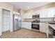 Well-equipped kitchen with stainless steel refrigerator, oven, and ample cabinet space at 11094 Arcadia Sunrise Dr, Henderson, NV 89052