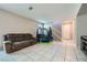 Open-concept living area featuring tile floors, a couch, and access to the staircase at 1111 Frye Mesa Ave, North Las Vegas, NV 89086