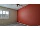 Bedroom featuring a red accent wall, ceiling fan, and shuttered window at 1147 Light Sky Ave, Henderson, NV 89074