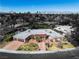 An aerial view of a charming greyscale single-story home with a two-car garage, desert landscaping and mountain views at 1409 Bonita Ave, Las Vegas, NV 89104