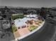 A greyscale aerial view of a house with a pool, desert landscaping, and two-car garage against a mountain backdrop at 1409 Bonita Ave, Las Vegas, NV 89104