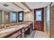 Vintage bathroom featuring double sinks, marble countertop, mirrors and glass door showers at 1409 Bonita Ave, Las Vegas, NV 89104