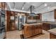 Modern kitchen with a stainless steel hood vent, center island, and stone countertops at 1409 Bonita Ave, Las Vegas, NV 89104