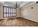 Bright living room featuring neutral walls, chandelier, and large window with shutter style blinds at 1409 Bonita Ave, Las Vegas, NV 89104