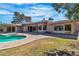 Backyard pool area with a kidney-shaped pool, brick-paved deck, and expansive sliding glass doors to the home at 1409 Bonita Ave, Las Vegas, NV 89104