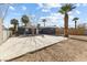 Expansive backyard with a concrete patio, fire pit, and mature palm trees at 1417 Joshua Way, Las Vegas, NV 89101