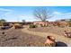 A tranquil backyard with a rock pond, walking path, and desert landscaping at 150 Spruce Ln, Pahrump, NV 89048