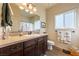 Bathroom with a spacious vanity, granite counters, wood-look tile flooring, and soft, neutral wall color at 150 Spruce Ln, Pahrump, NV 89048