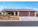 Inviting single-story home with desert landscaping, a three-car garage, and a covered front porch at 150 Spruce Ln, Pahrump, NV 89048