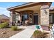 Inviting front porch with stylish stone pillars, seating, desert landscaping, and a secure front door at 150 Spruce Ln, Pahrump, NV 89048