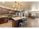 Open concept kitchen with stainless steel appliances, granite counters, pendant lighting, and seating around a large kitchen island at 150 Spruce Ln, Pahrump, NV 89048