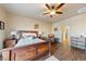 Bedroom with wood-look flooring, a ceiling fan, a dresser, and a doorway to the bathroom at 150 Spruce Ln, Pahrump, NV 89048